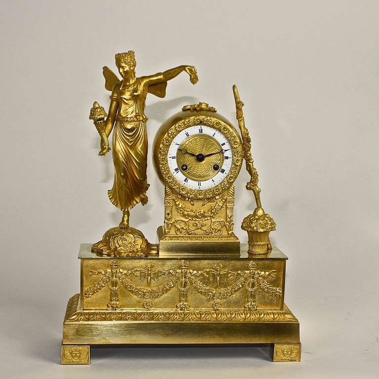 White enamel and guillioche gilt-bronze dial within a square shaped case flanked by a winged 