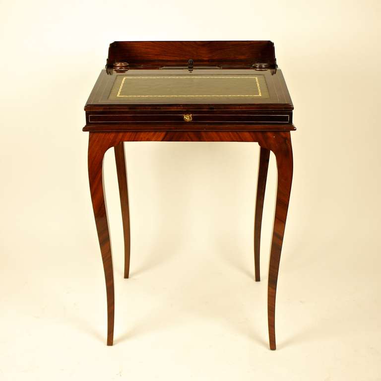 Mahogony bonheur de jour with a rectangular hinged  top fitted with a leather lined writing surface, opening to reveal two drawers, raised on cabriole legs.