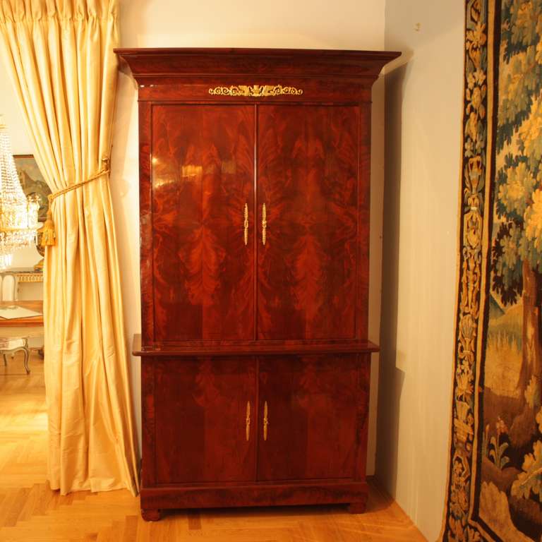 Beautiful and generously proportioned linen press in Cuba mahogany, with gilt-bronze mounts, Pasquill lock and interior shelving. The pediment consist if a secret chest, accessible from the top.