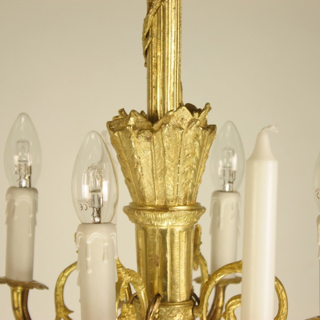 A 19th century gilt bronze chandelier in the manner of Pierre Gouthiere (1732-1813), a quiver-shaped ceiling fixture issuing four twisted candle arms with scrolled branches and rooster heads surmounted by another four electrified candle arms. The