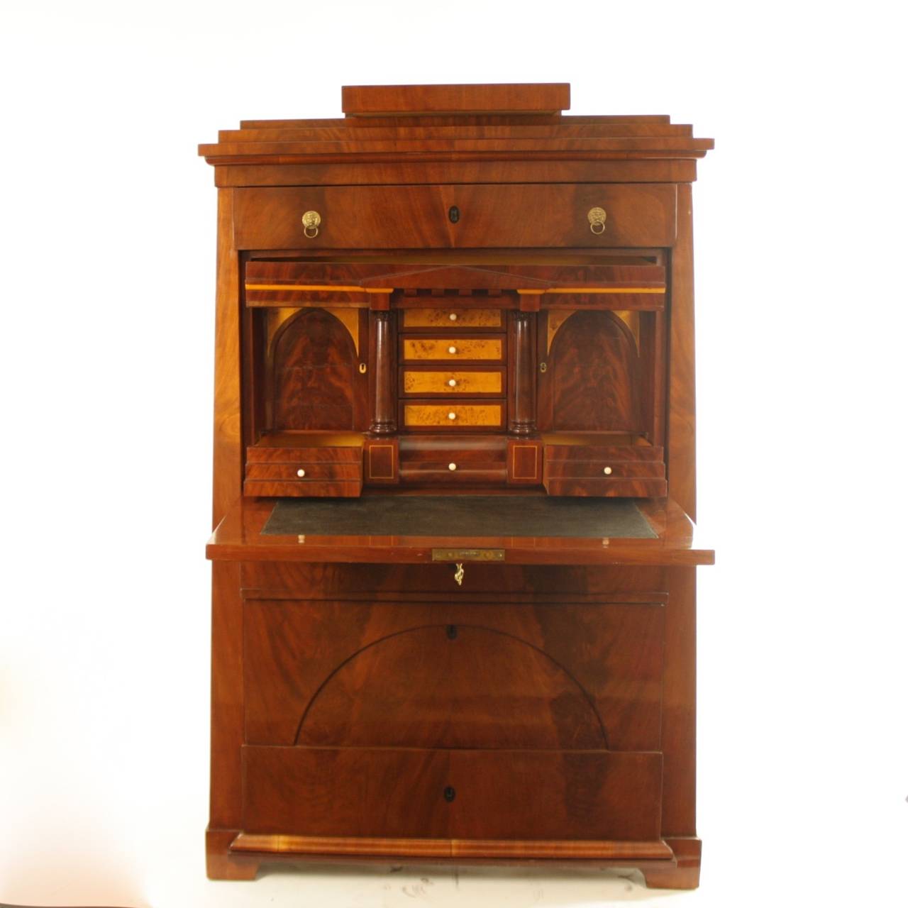 An early 19th century Biedermeier fall front secretaire of tapering shape with a Schinkel pediment including a top drawer, above a fall front fitted with a leather-lined writing surface and a fitted interior consisting of ten drawers and two doors,