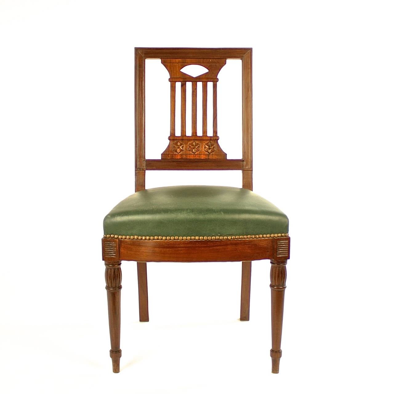 Pair of early 19th century mahogany side chairs in the manner of Bellange Frères. Raised on turned tapering front legs and sabre rear legs, carved with pierced splades in the shape of a pilaster and adorned with carved paterae, upholstered with dark