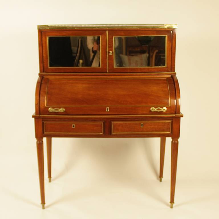 French 19th Century Brass Inlaid and Mahogany veneered Directoire Style Cylinder Bureau

A 19th century mahogany cylinder bureau with the rectangular top surrounded by a pierced brass gallery, above two mirrored panelled doors, the roll-top opening