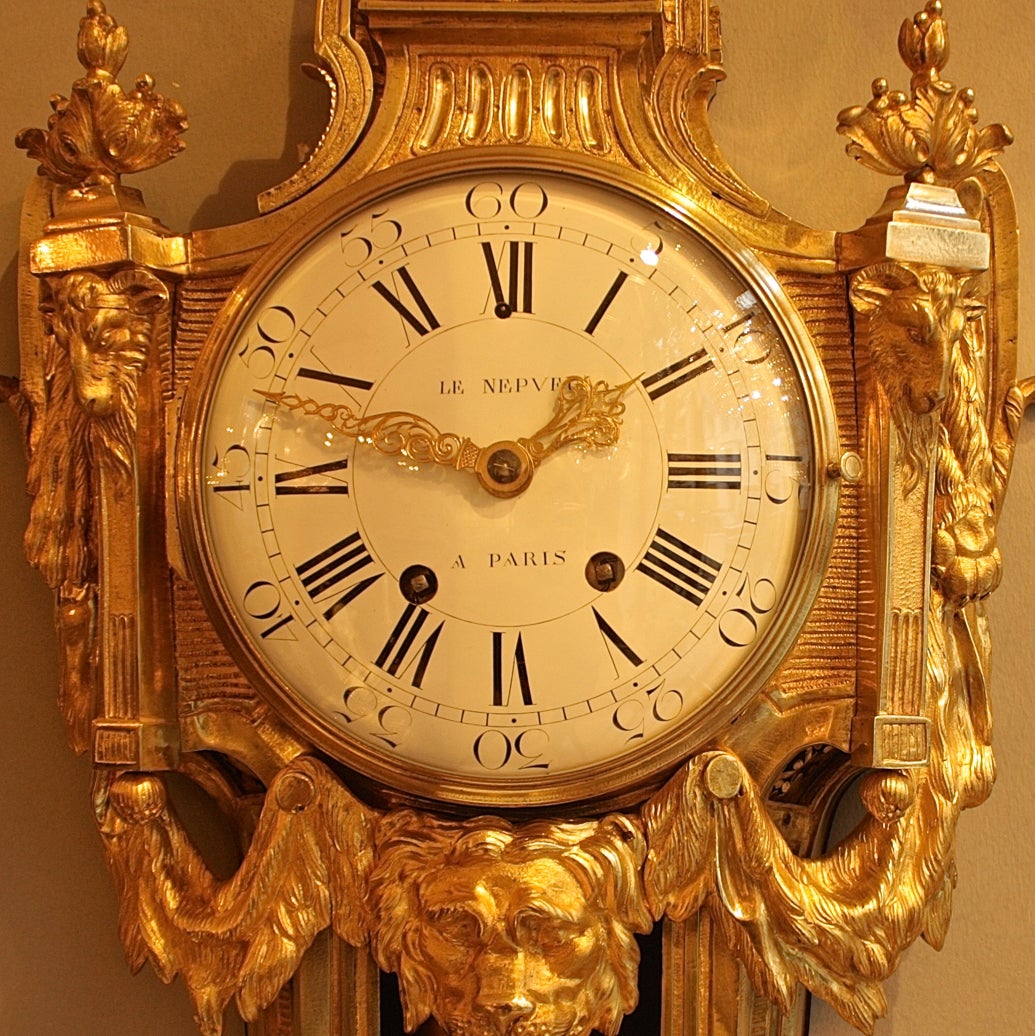 An 18th century gilt-bronze Cartel clock with a white enamel dial signed Le Nepveu a Paris, with finely pierced and engraved gilt hands, the Roman and Arabic numerals contained within a cartouche-shaped case with a 'Vitruvian wave' frieze surmounted