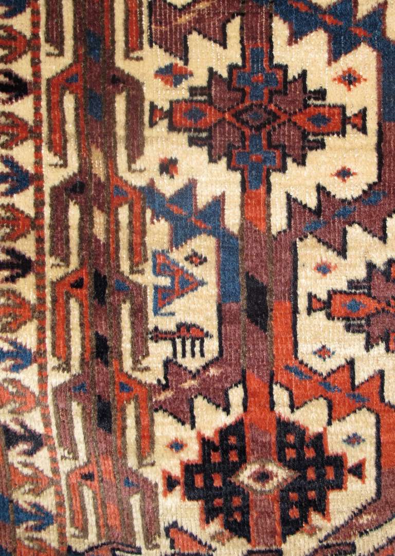 Stylized, blossoming trees are melded into a lattice against an ivory ground to form the field of this Yomut asmalyk, a pendentive camel trapping traditionally woven for Turkmen weddings. This composition is flanked by two other forms of stylized