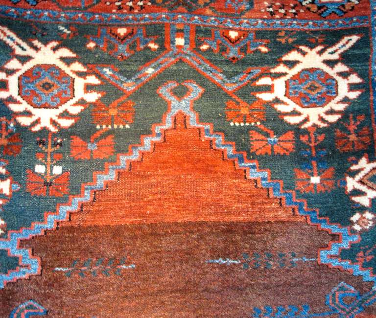 This Anatolian prayer rug is a tactile sensation. Woven with thick but exceedingly soft wool, darker background colors such as ox-blood reds and contrasting forest greens are punctuated by intense highlights of medium blues and rose. This