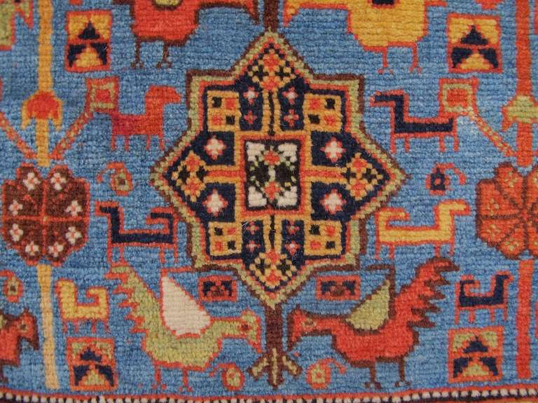 Along with its mate, this Khamseh bag has become one of the most iconic examples of tribal weaving from the Southwest Persian region of Fars. Against a clear sky-blue field, stylized flowers culminating in blooms of classic Khamseh star ornament are