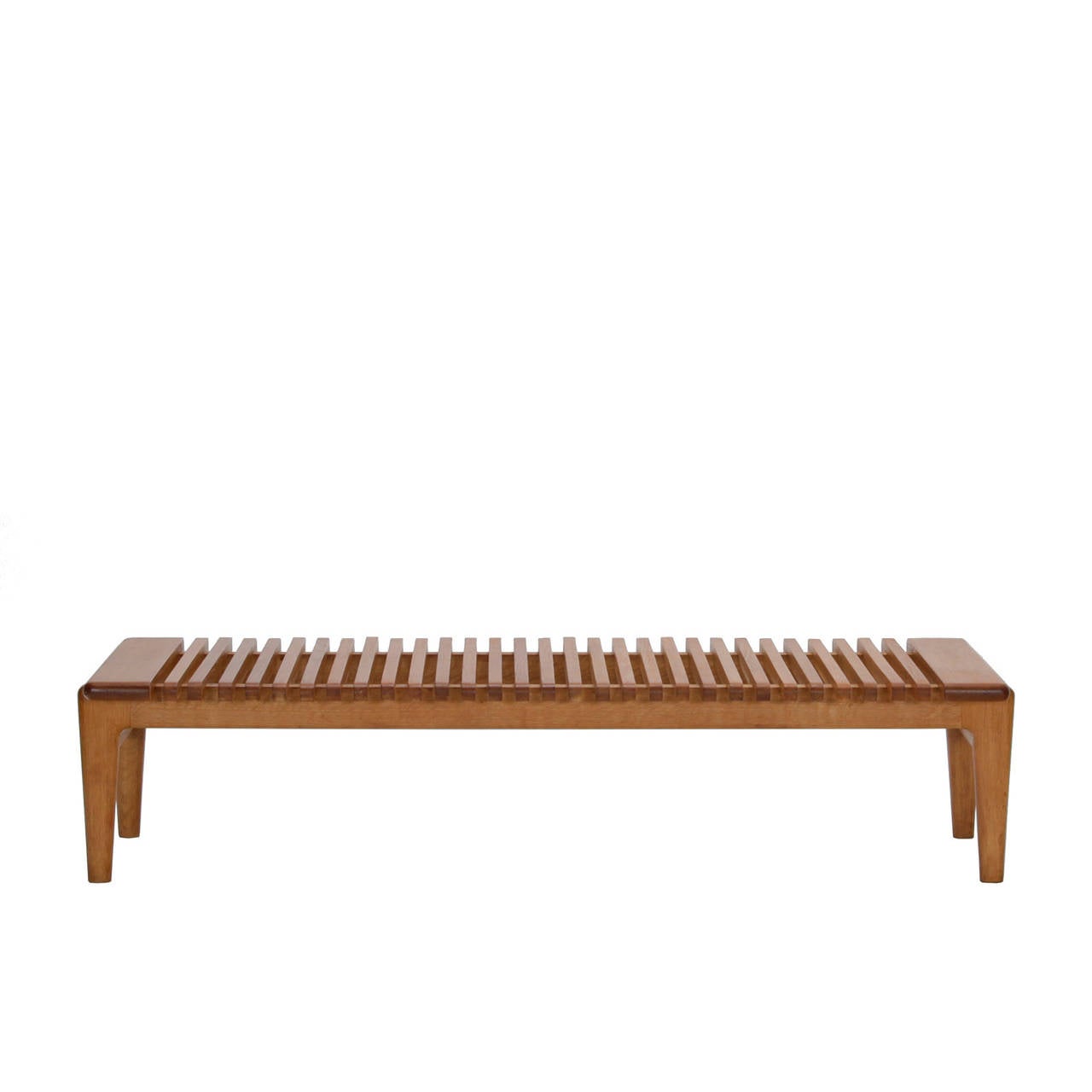 A bench in solid oak equally suited to use as a coffee table. Designed by Hans Wegner for cabinetmaker Johannes Hansen, Denmark