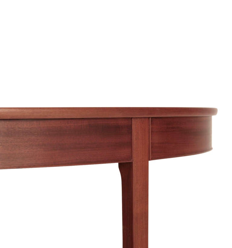 A round dining table in Cuban mahogany on feet of rosewood. Two extra leaves in pine of each 55 cm. Total length 235 cm / 92.5 inches. Designed by Ole Wanscher c. 1954. Made by cabinetmaker A. J. Iversen, Denmark