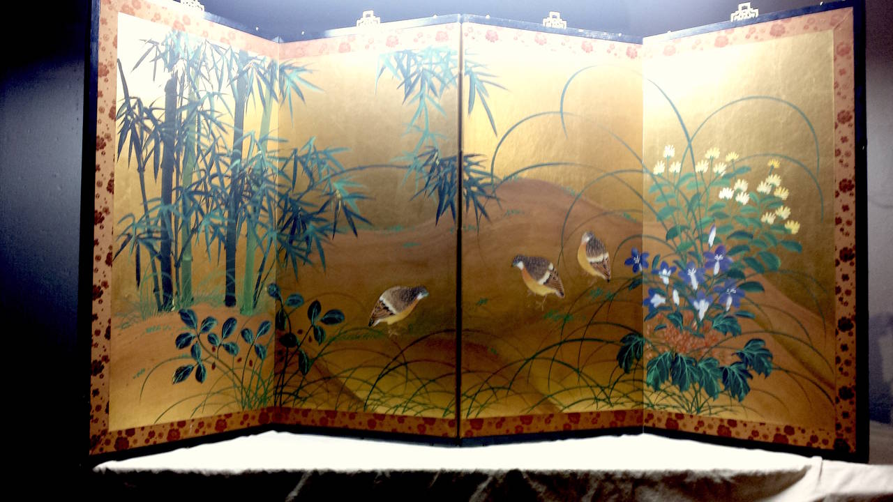 This is a vintage Asian wood four panel wall hanging silkscreen or divider. Has a painted scene of quails in a landscape on a gold foil paper, some of the paint is flaking but mainly the leaves on the trees. The border is a fabric with what looks