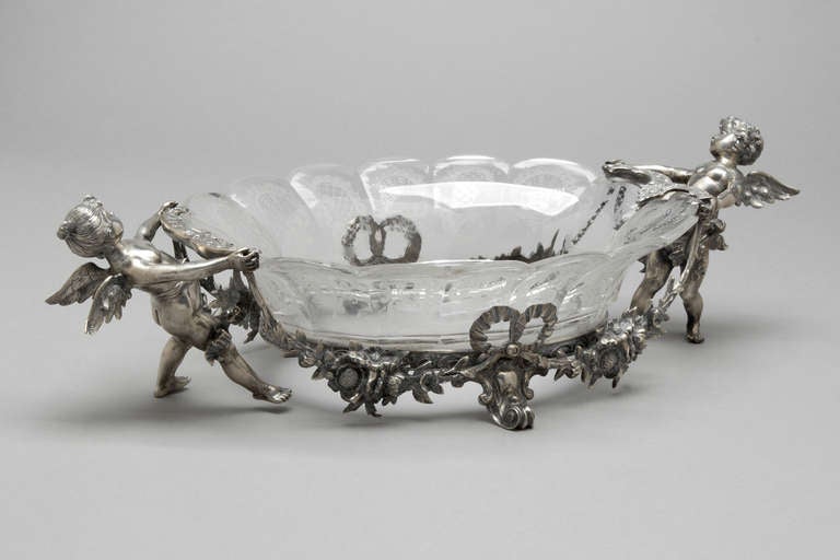 A very finely engraved glass and sterling silver table centerpiece-jardiniere.  The silver mount is chased with cherubs and swags, the original glass finely engraved.  Dutch circa 1880.

Ht 4 inches
L  13 inches