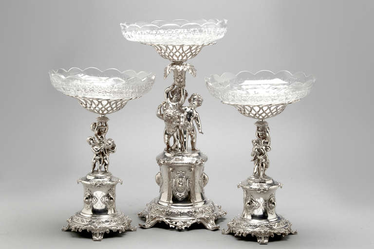 A suite of plated centerpieces with glass liners.  English, Victorian circa 1865.  Maker Thomas Bradbury & Co.  They are complete with cut glass dishes that are in perfect condition.

Ht 22 inches and 16 inches