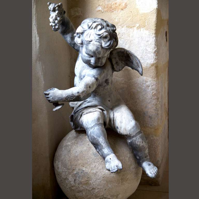 Lead cherub on a stone ball.
Cherub height 82cm