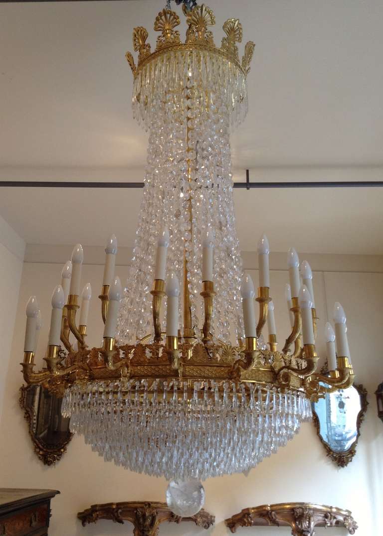 Large Empire style chandelier in finely carved gilt bronze with crystal droplets, comprising 36 lamps on two rows.<br />
19th century.