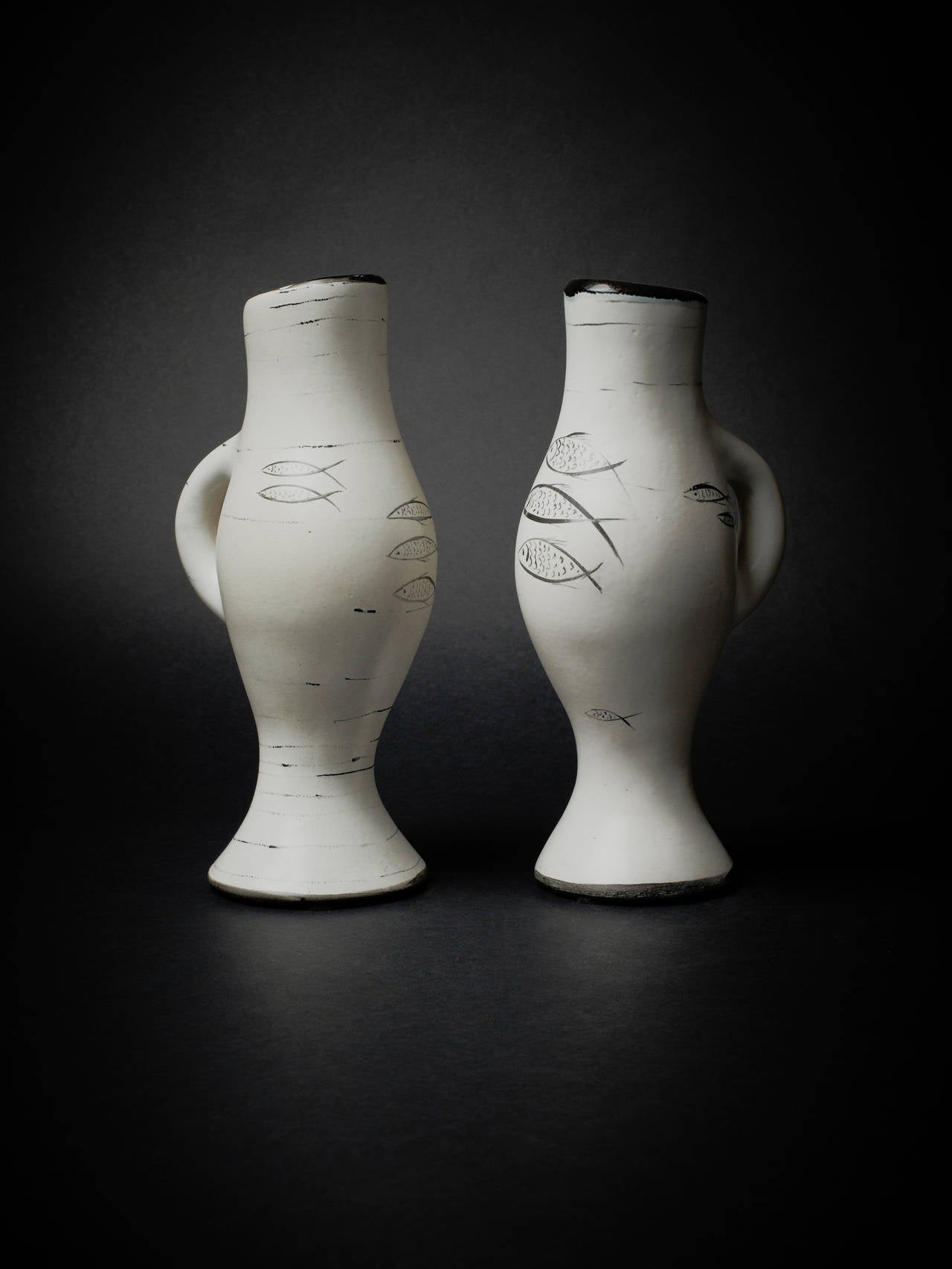 Denyse gatard (1908-1991), ceramist, sister of Georges Jouve. Pair of black and white enameled pitchers with round shapes and fish decor typical from the artist. Signed DG.