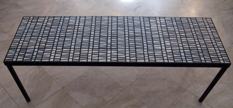 Roger Capron (1922-2006). Coffee table composed of a grey, grey blue and white ceramic tiles top and blackened iron legs. Dimension: 120cm x 40cm.