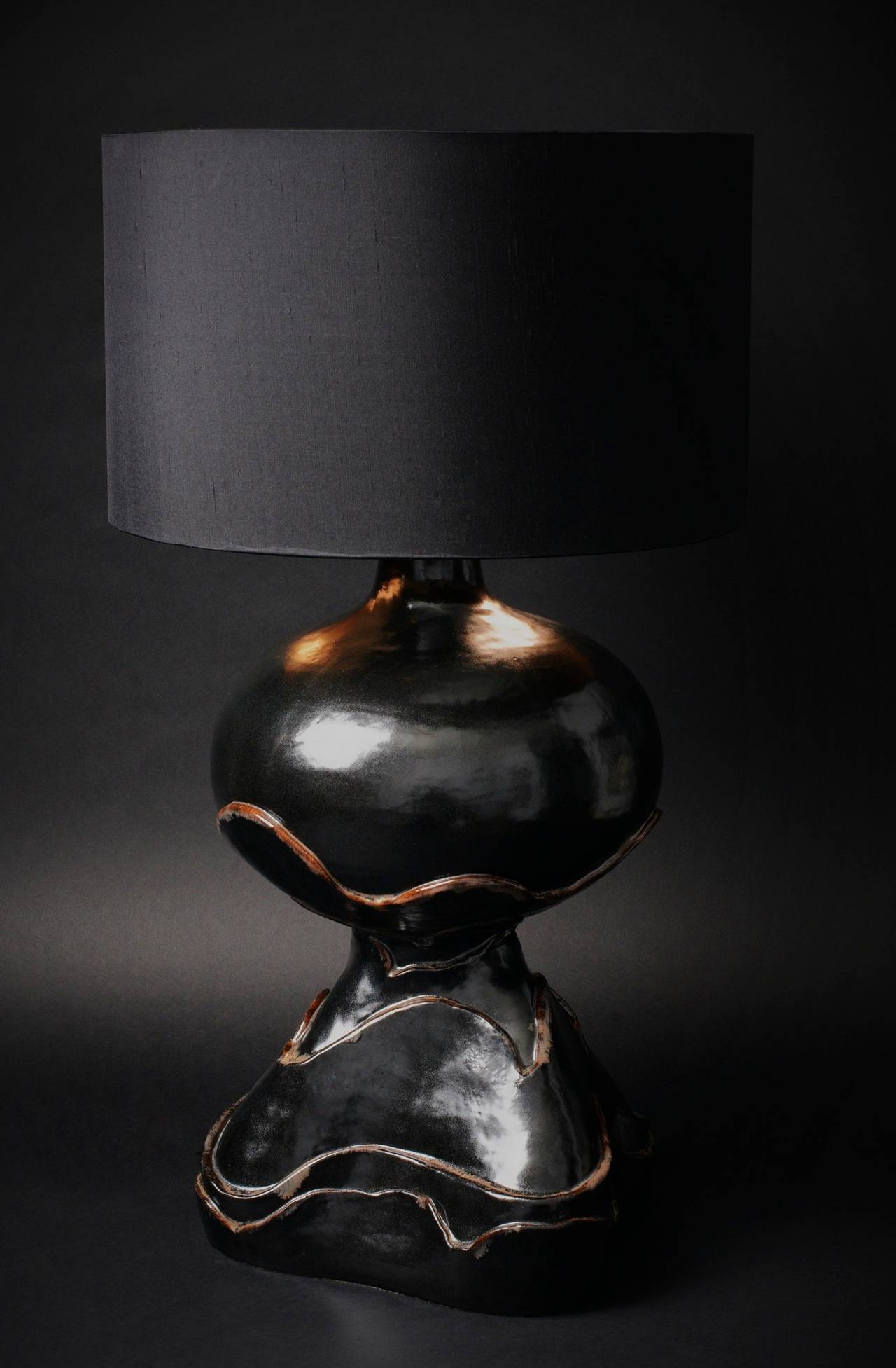 Large free shape black enameled sandstone table lamp. 2014 creation of the French ceramic artists DALO.

Daniel & Loic (DALO) are designing together since 2007 original ceramic pieces. Inspired by the second part of the 20th Century French