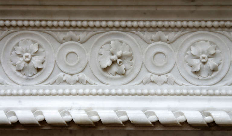 It's hard to find a Louis XVI more refined than this one.

In every circle, a different flower...
The whole surrounded by pearls...
Ribbons everywhere, roses and acanthus leaves on the jambs...
In short, this fireplace is an artistic explosion