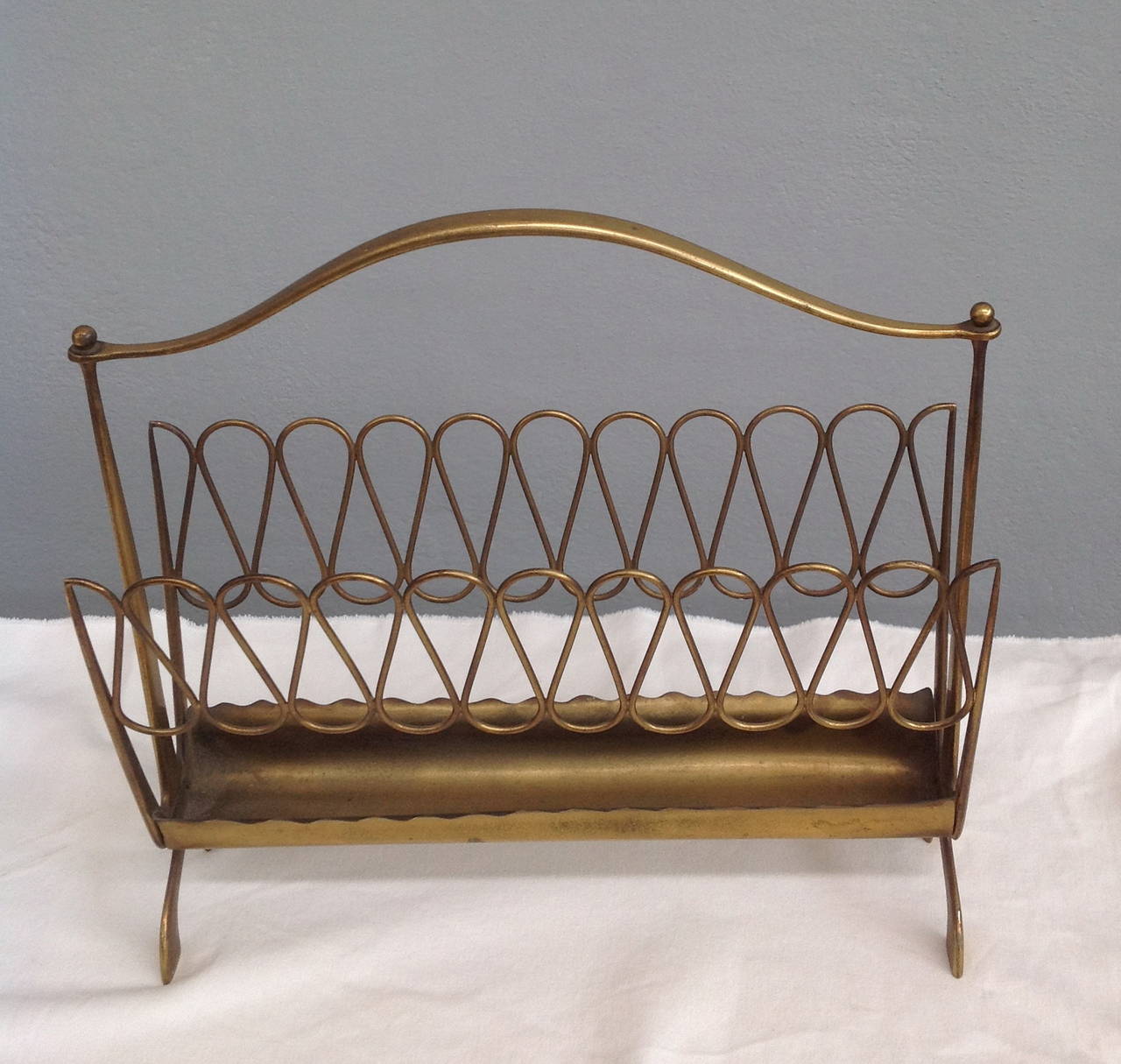 nice shaped brass magazine rack in the style of Gio Ponti