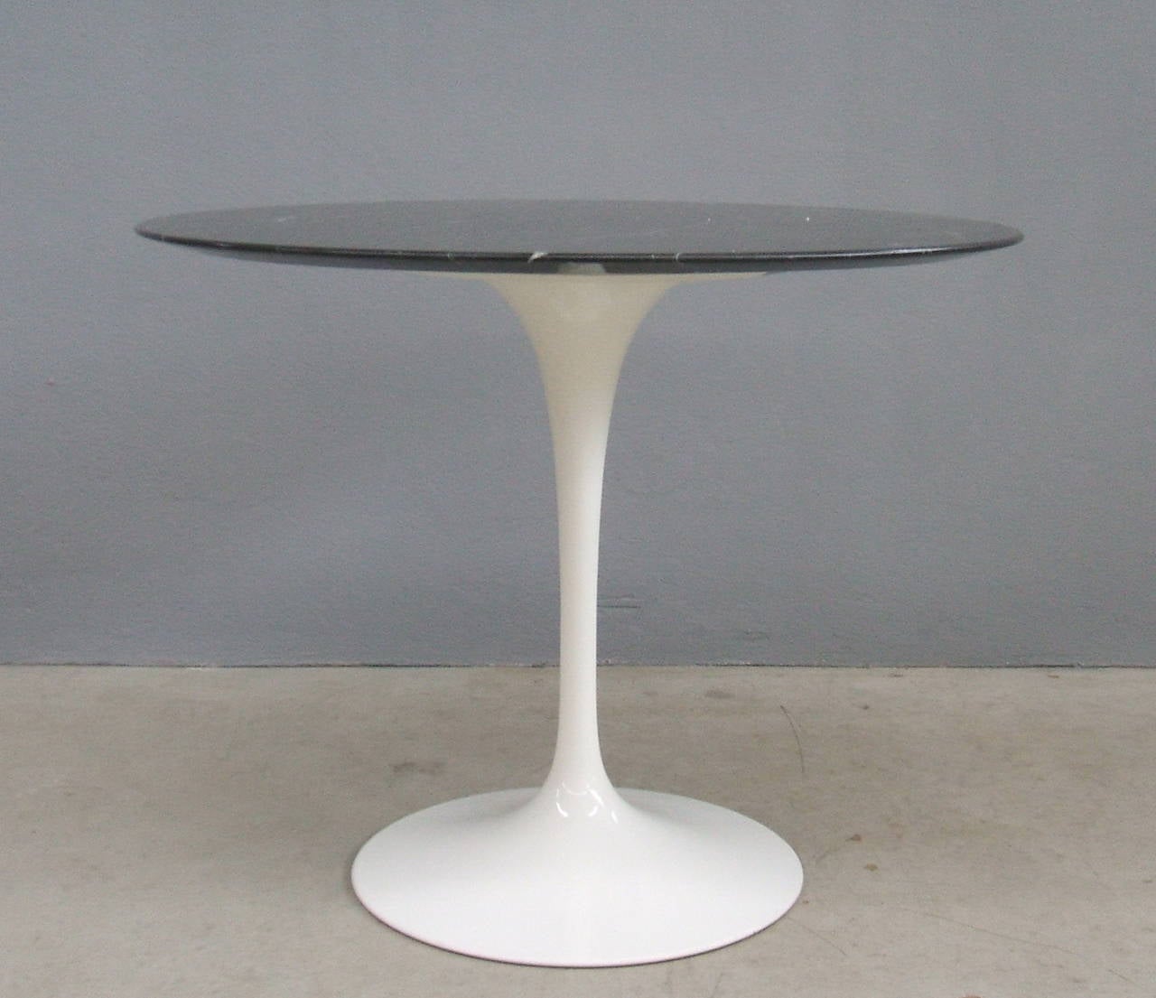Pedestal table designed by Saarinen in 1956 and produced by Knoll International. Foot in cast aluminum white paint and tabletop in black marble.