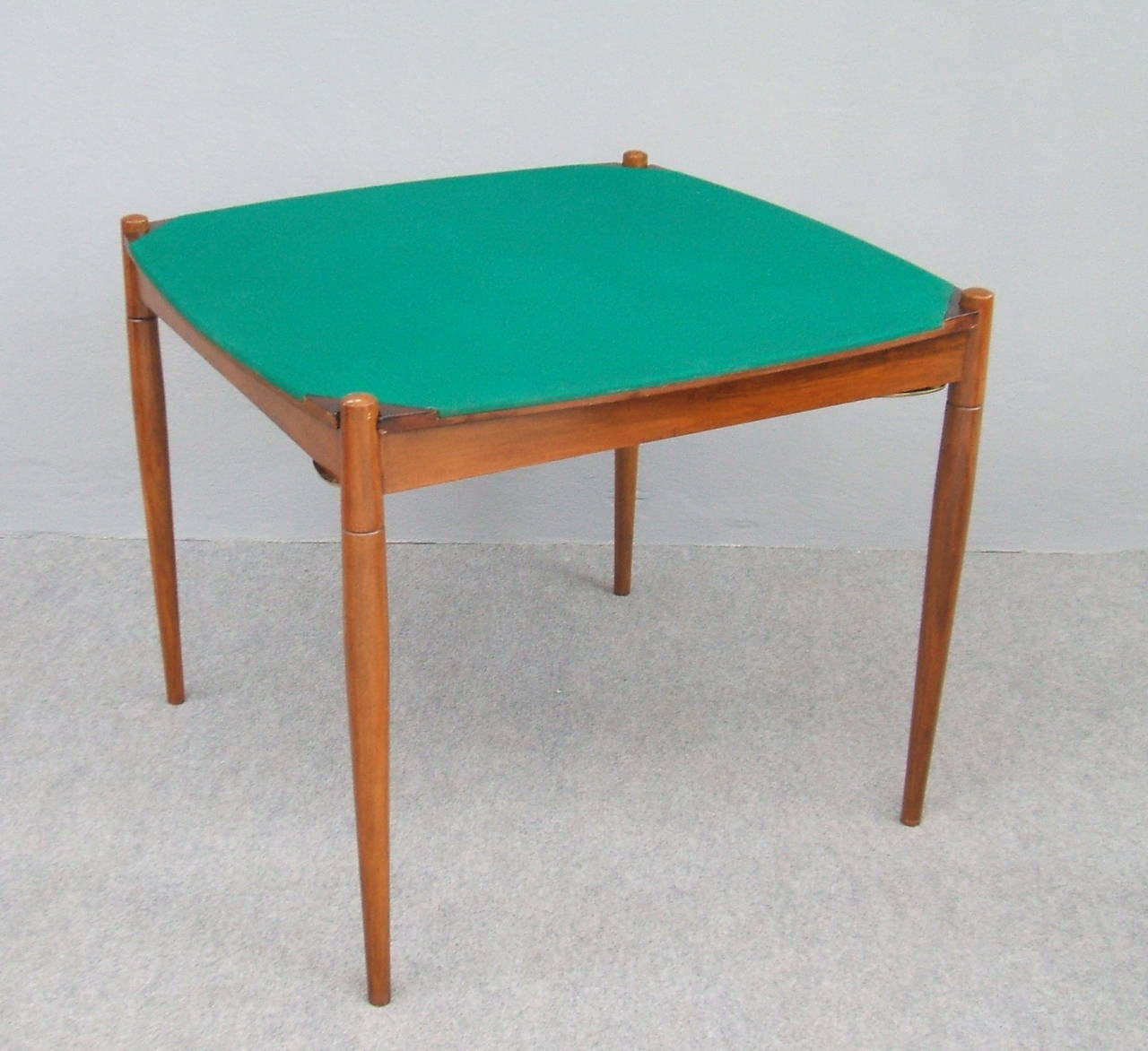 Famous game table designed by Gio Ponti for Reguitti as marked on the back.
Reversible top, green velvet or wood( palisander).. Brass sides in the corners.