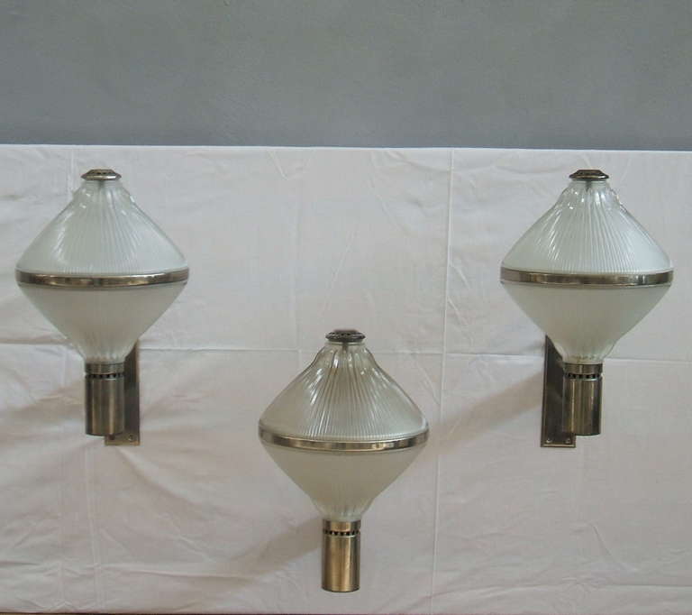 Three  chrome and glass wall sconces designed by studio BBPR for Artemide.
Very nice glass and very good condition with age.