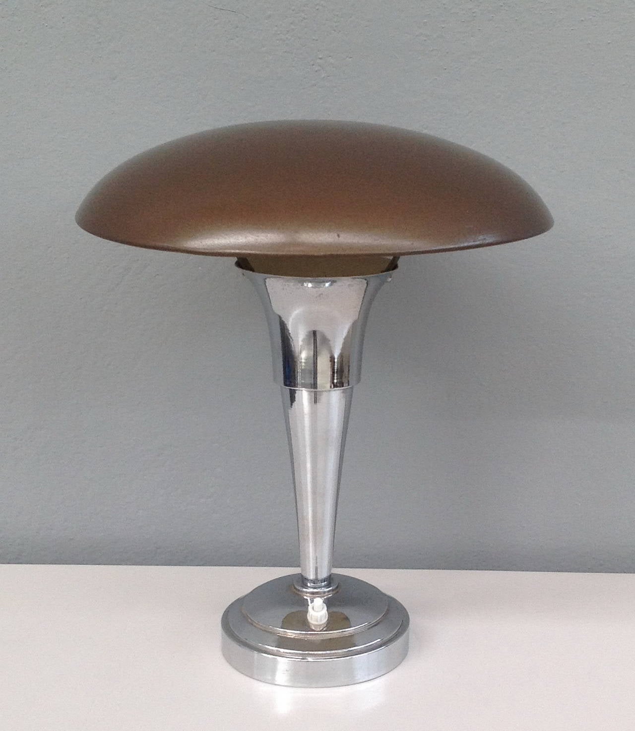 Chrome table lamp with lacquered metal top.