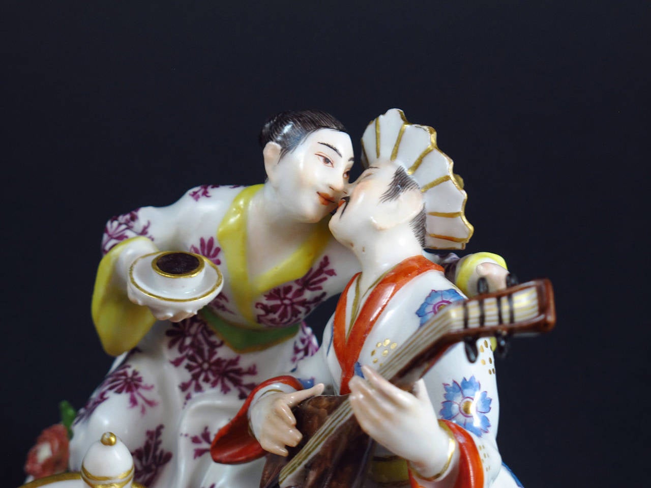 By Johann Joachim Kaendler
Meissen Model nr. 610

An Oriental couple is sitting behind a gilt-edged white tripod table covered with a coffee service. A parrot is sitting on one table leg. The lady is embracing the gentlemen who plays the lute.