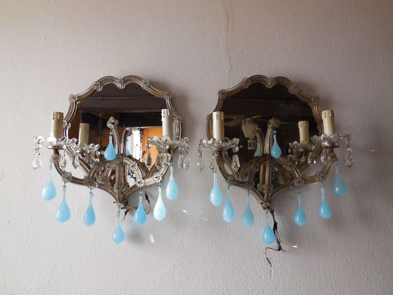 Housing 2 lights each, sitting in a rare shape bobeche just dripping with rare vintage crystals.  Gold gilt metal is covered with Murano blown glass.  Florets galore.  Adorning 8 huge rare blue opaline drops with matching beads above.  Mirrors are