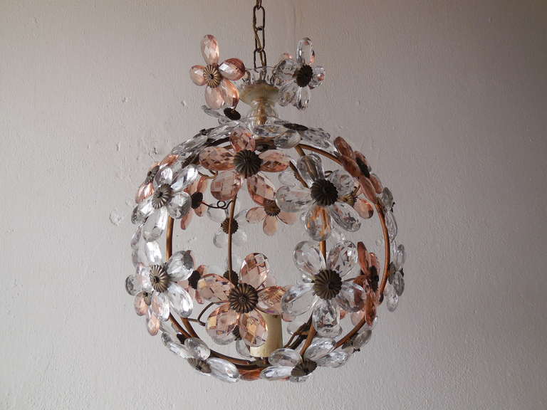 Wonderful rare Maison Bagues ball shape chandelier found in the South of France. Housing 1 light in center, bulb holder in wood. Adorning 41 crystal prism daisies in pink and clear. Blown glass on top.  Adding 24