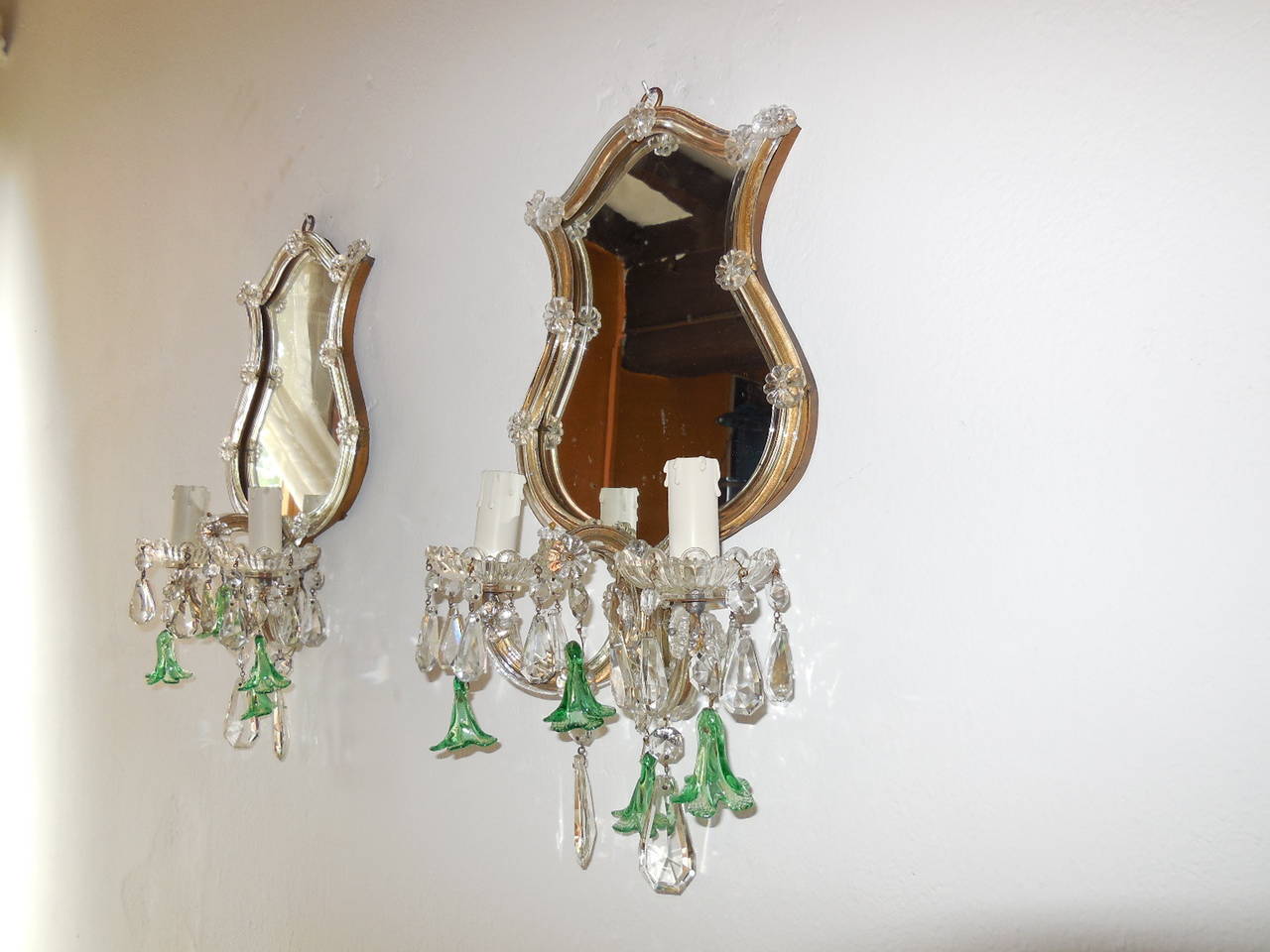 Housing 2 lights each, sitting in crystal bobeches.  Crystal prisms and Murano green bell flowers.  Gilt metal with clear Murano glass covering.  Mirrors have a bit of silver missing.  Re-wired for US and ready to hang.  Free shipping from Italy.