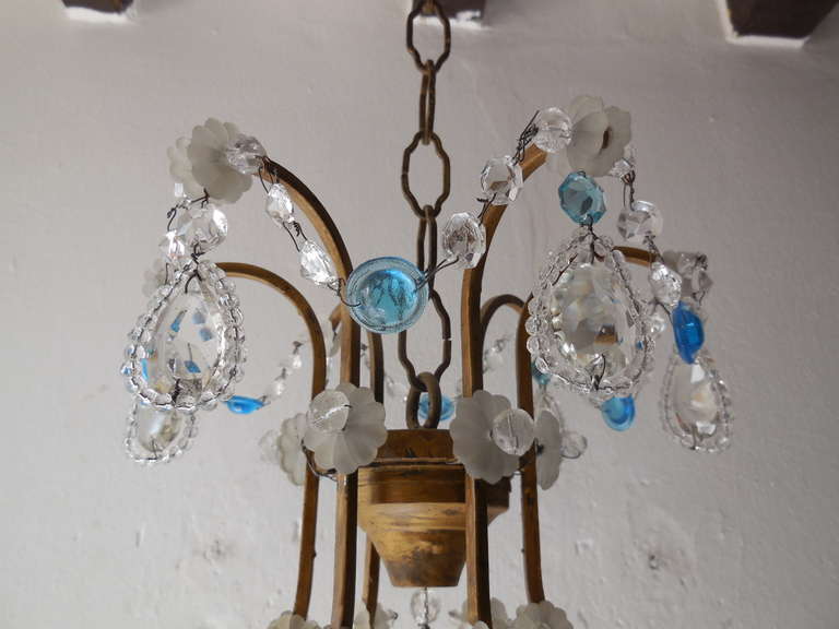 Beautiful old chandelier . All complete. Housing 6 lights, sitting in crystal bobeches, dripping with blue and clear prisms. Adorning rare round blue prisms with crystal spear in center. Adding another 14