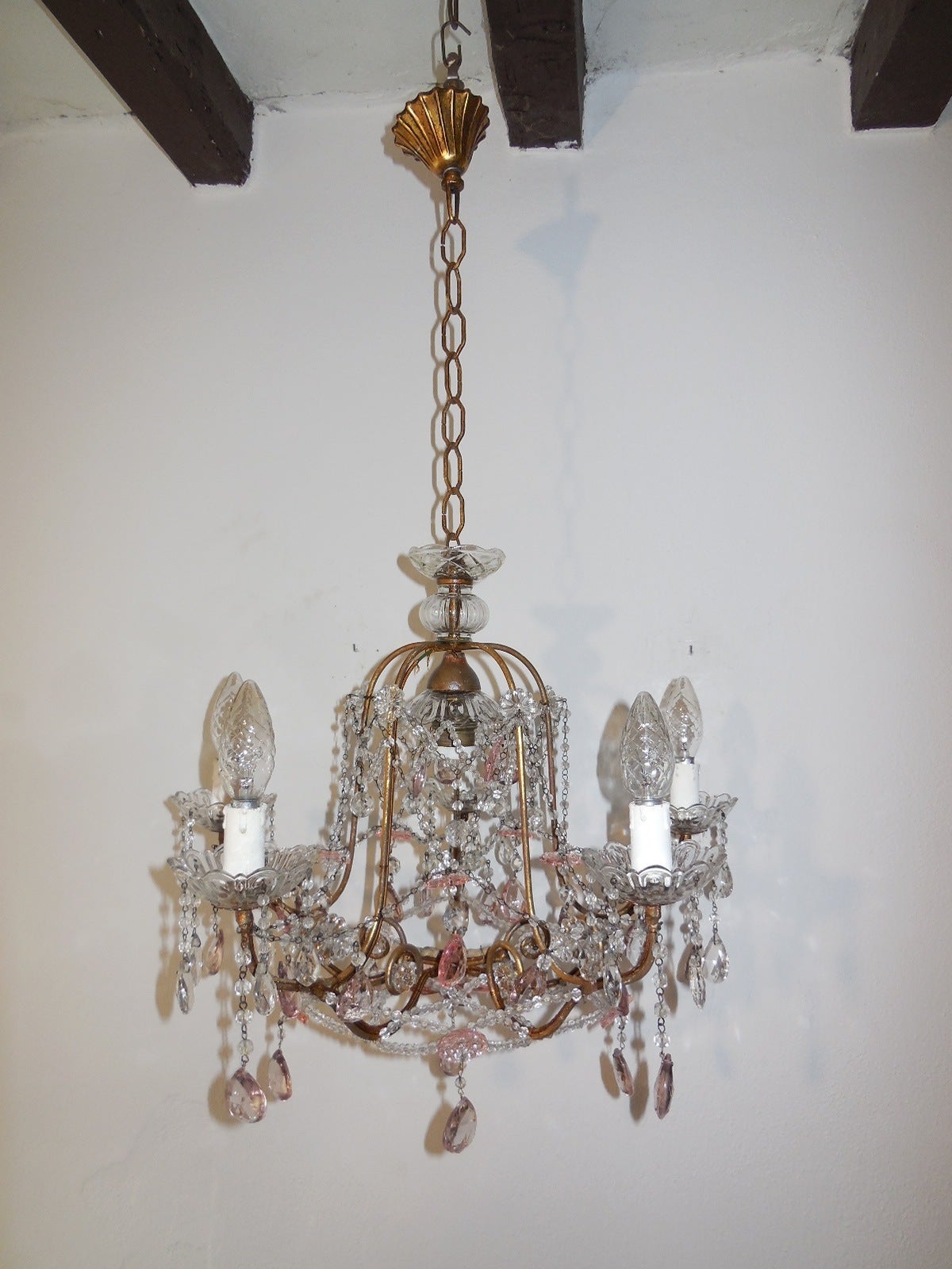 Housing 6 lights, 5 sitting in crystal bobeches, just dripping with crystal prisms.  The other one is in center.  Gold gilt body with florets and prisms throughout.  Also, pink flower on bottom.  Adding another 16 inches of original chain and