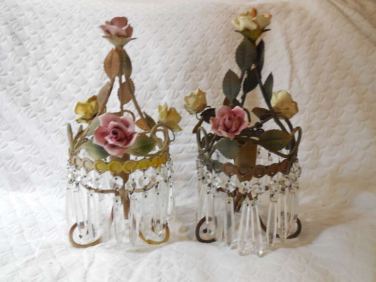 Housing one light.  Adorning four porcelain. handmade roses in pink and yellow.  Some petals have chipped.  Tole leaves.  Adoring rare vintage crystal prisms.  Re-wired and ready to hang!  Free priority shipping from Italy.