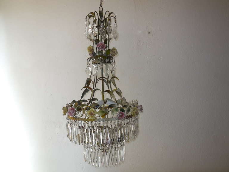 Housing four lights.  Green tole leaves galore.  Original color tole.  Four tiers of vintage crystal prisms, all rare.  Also adorning French hand made porcelain roses in pink and yellow.  Adding another 18