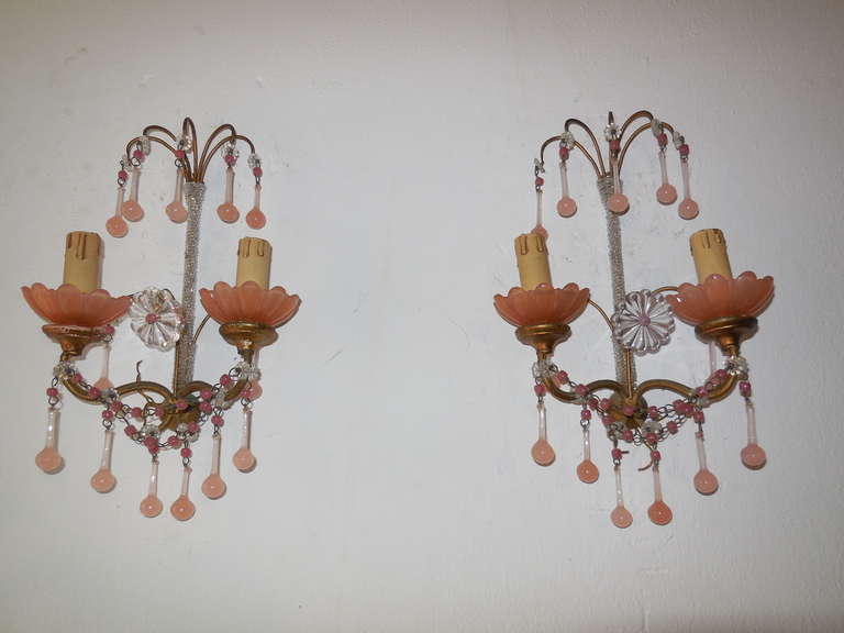 Housing two lights each. Gilt metal and wood. Pink opaline bobeches. Adorning 26 small pink opaline drops and beads on top. Swags of beads as well. Micro beaded back. Huge glass floret in center. Will need to be rewired for U.S. safety standards.