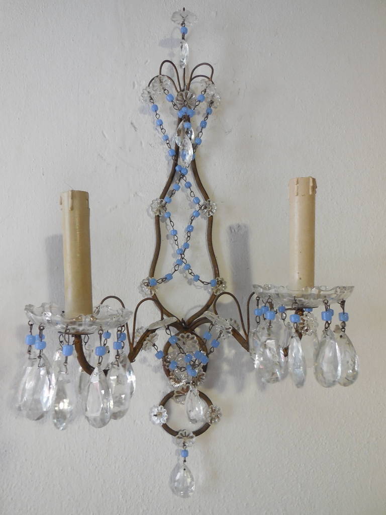 Housing two lights, bulb holders are long and wooden, sitting in rare crystal bobeches. Extremely rare purple opaline beads and swags. Florets and crystal prisms throughout. I took a picture with a blue opaline drop so you can have a better idea of