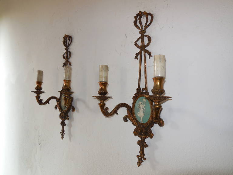 Housing two lights each. Cast bronze with perfect patina and wonderful detailing. Two bows on each. Robins egg Jasperware with white woman. Will need to be rewired for U.S.