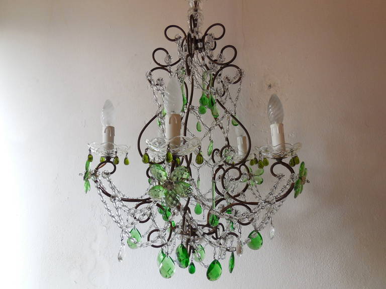 Housing five lights, sitting in crystal bobeches. Murano green drops.  Swags of crystal macaroni beads.  Adorning green prism flowers and prisms. Crystal bobeches on top and bottom as well.  Canopy and chain add 12 inches. Re-wired and ready to
