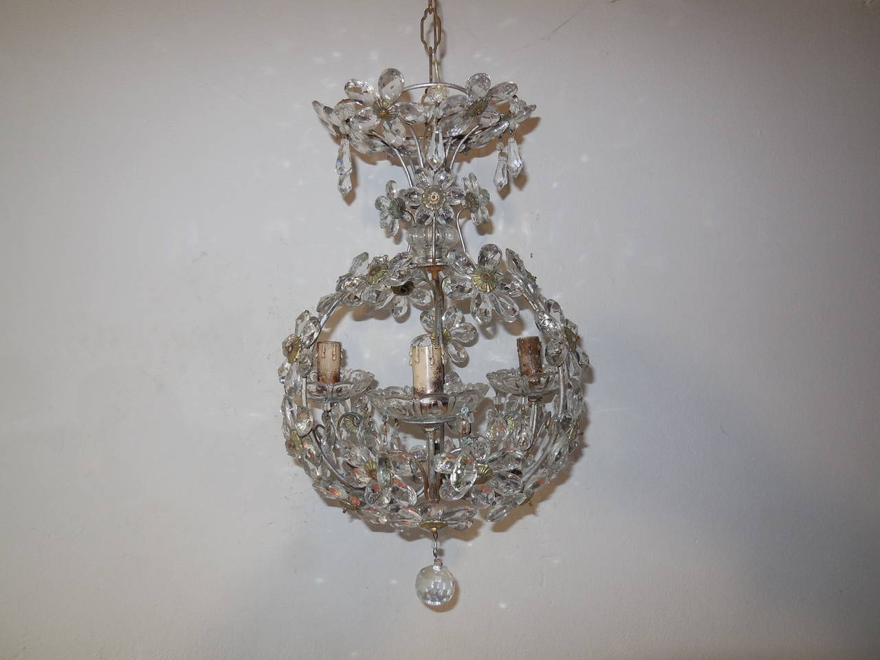 Beautiful Bagues chandelier housing an impressive 3 lights, sitting in crystal bobeches dripping with vintage prisms.  Silver metal body.  Murano glass on top.  Crystal prism flowers throughout, even on top!  Rewired and ready to hang!  Free
