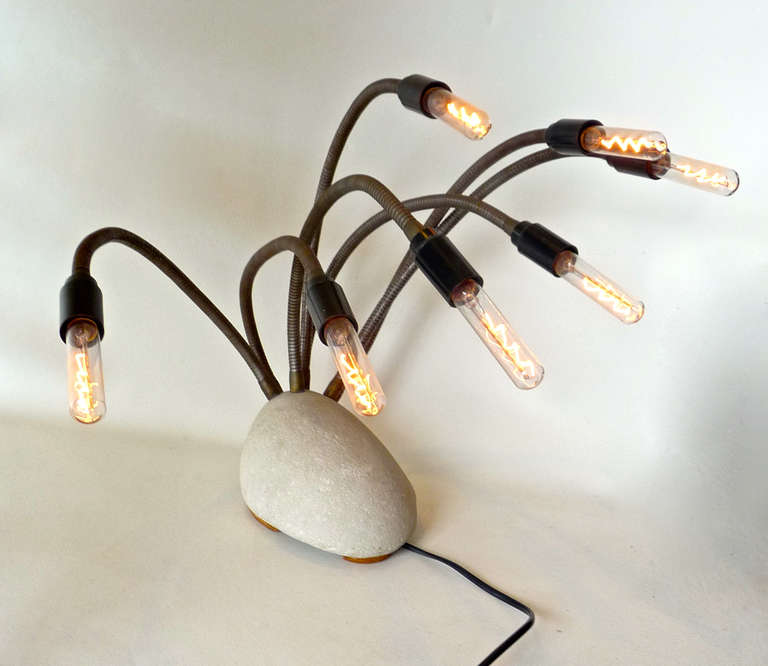 This contemporary lamp has 7 beautiful lights on bendable arms

Hence the name ‘Septopus’

Electric candlestick. Ölandstone with seven flexible brackets of unprocessed iron with clear candle lamps (with dimmer). Because no two stones have the
