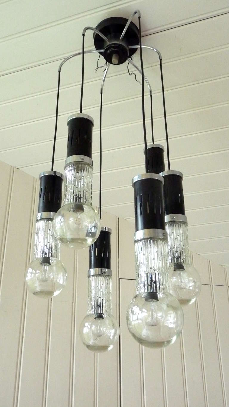 multi drop chandelier with six glass bulb shaped shades hanging from different heights held together by the ceiling rose. The small fitting lightbulbs are enclosed by the relief glass bulb shaped shades which are easily screwed into their metal