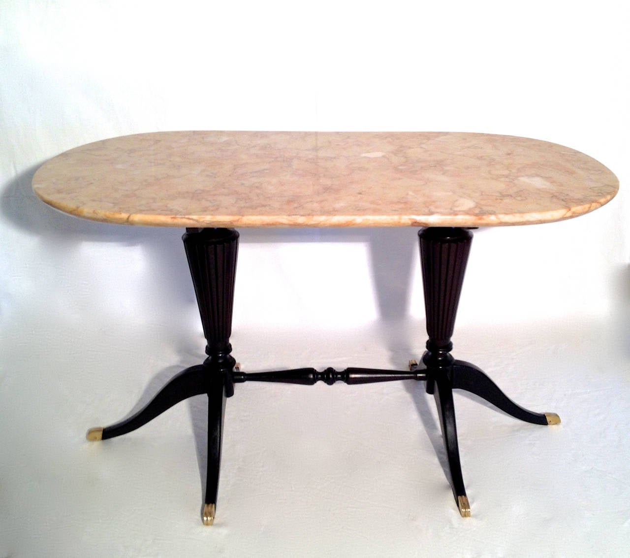 Very rare and elegant 1940s Italian design table with oval shaped salmon coloured marble top on articulate double foot base with centre rod and with brass details. The table is signed and numbered with the manufacturer's label.
