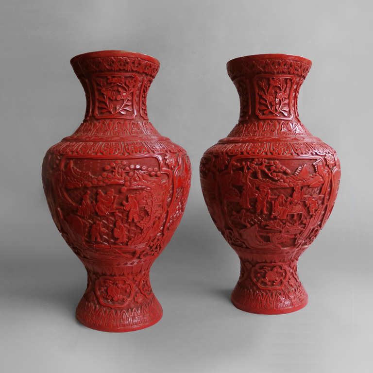 A pair of large Cinnabar lacquer vases, the bodies carved with incised decoration of figures, pagodas and landscapes.