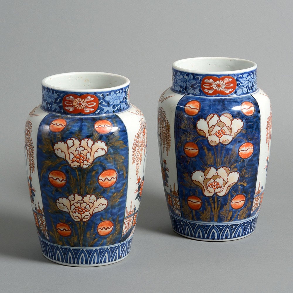 A pair of late 19th century Imari porcelain vases, the bodies articulated by panels of floral motifs and still life panels in blue red and gilt glazes. 

These vases were produced shortly after the re-opening of the Japanese ports to export trade