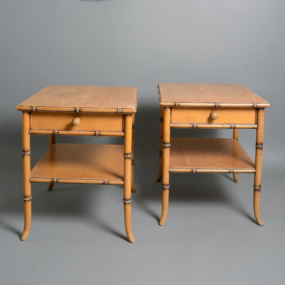 A pair of mid-20th century bedside tables, each having a frieze with central drawer, set upon faux bamboo turned legs, supporting a lower shelf. 

These tables belong to the classic revival tradition promoted shortly after the Second World War by