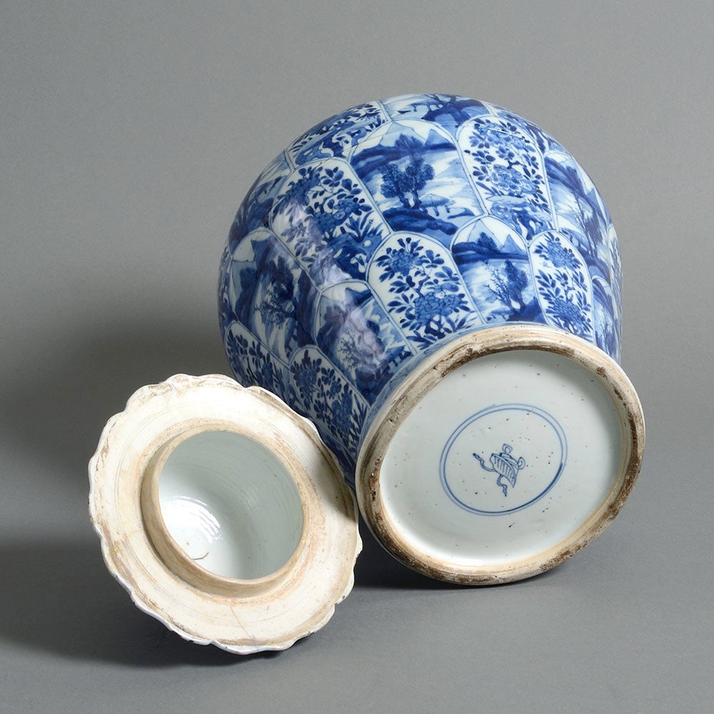 An early 18th century blue and white porcelain vase, of baluster form, the body decorated throughout with alternating floral and landscape panels, the lid with similar decoration and shaped finial. 

The Emperor Kangxi regained from 1661-1722. He