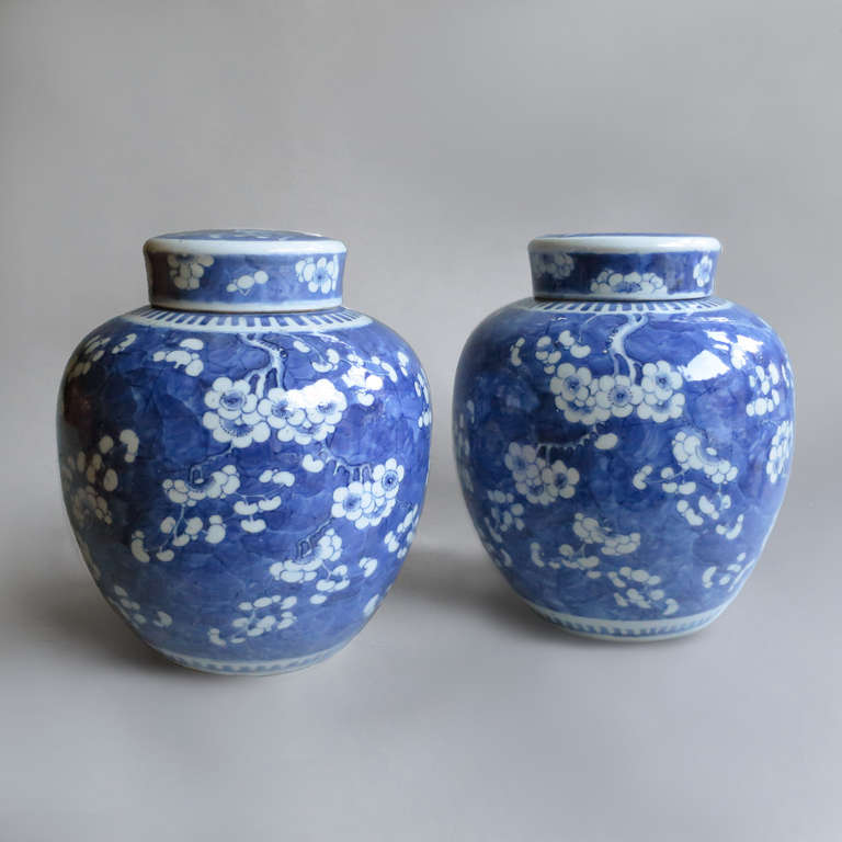 A Pair of Blue and White Porcelain Ginger Jars, decorated with a prunus blossom motif and retaining the original lids.