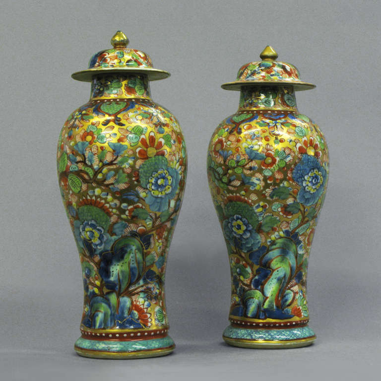 A pair of late eighteenth century clobbered vases of baluster form, retaining their original covers