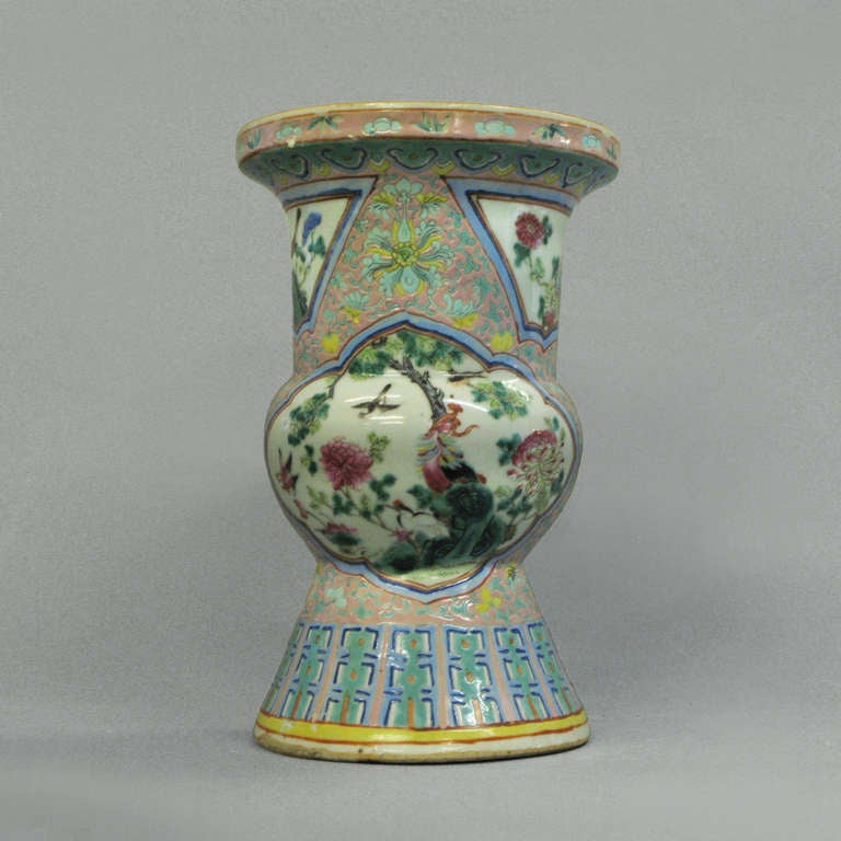 A famille rose beaker vase of good scale, the body decorated with shaped cartouches depicting birds amid flowers and trees